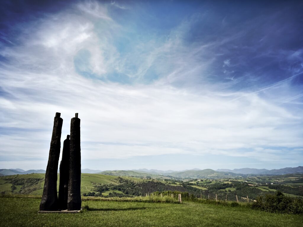 Ein steinernes Team auf einer Wiese vor einem weiten Himmel.